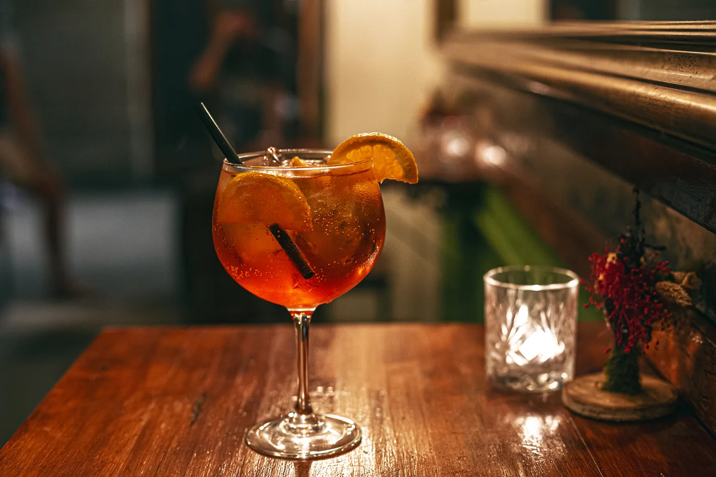 Cóctel con naranja en la barra de madera